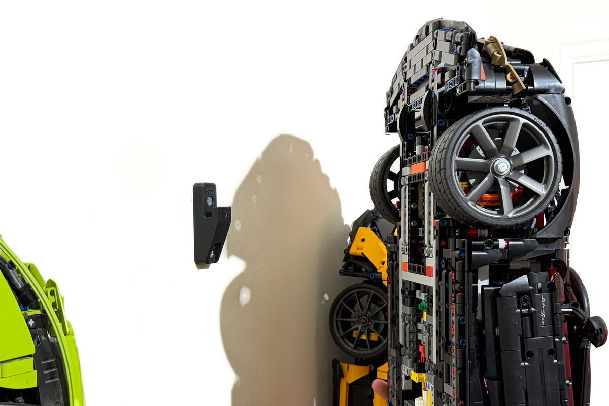 Wall bracket beside the LEGO Technic Koenigsegg Sadair's Spear Megacar 42232 before mounting.